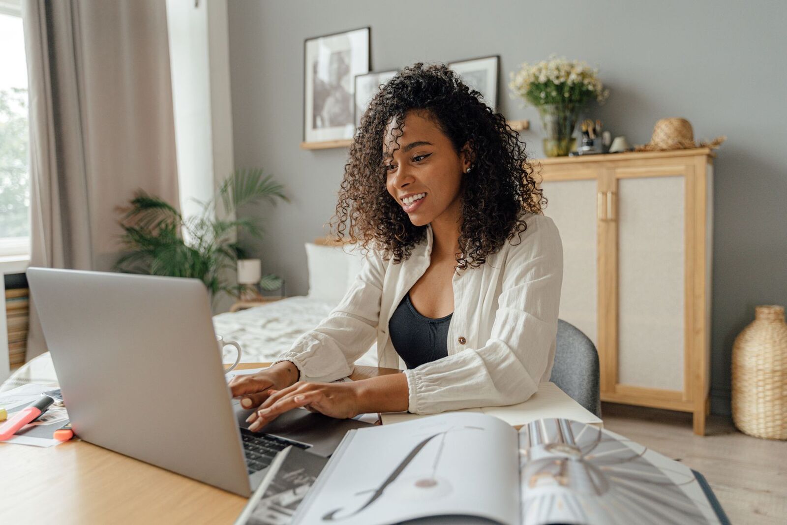 Woman smiling as she works at a laptop from home